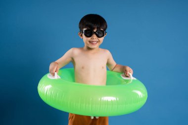 Mavi arka planda poz veren Asyalı çocuk portresi