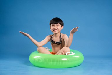 Mavi arka planda poz veren Asyalı çocuk portresi