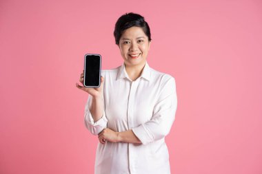 Pembe arka planda poz veren yaşlı Asyalı iş kadını