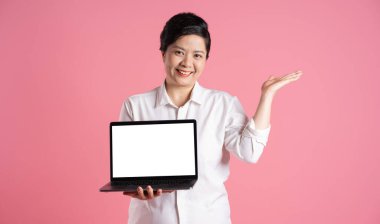 Pembe arka planda poz veren yaşlı Asyalı iş kadını