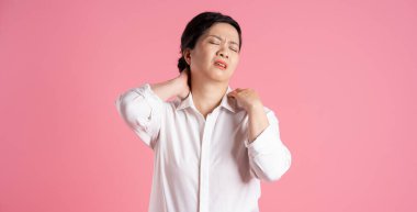 Pembe arka planda poz veren yaşlı Asyalı iş kadını