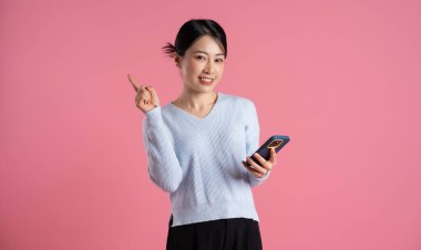 Pembe arka planda poz veren güzel Asyalı kadın portresi