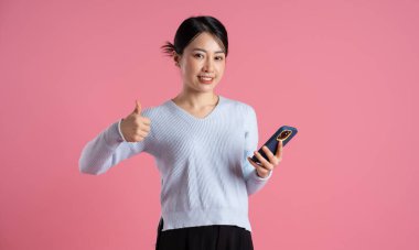 Pembe arka planda poz veren güzel Asyalı kadın portresi