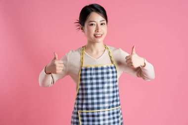 Pembe arka planda poz veren önlük giyen kadın portresi