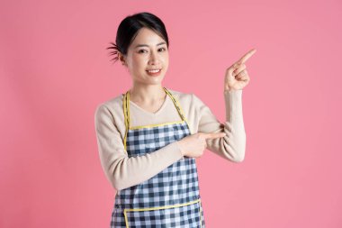 Pembe arka planda poz veren önlük giyen kadın portresi