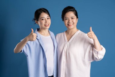 Mavi arka planda poz veren Asyalı bir anne ve çocuğun resmi