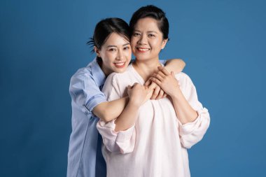 Mavi arka planda poz veren Asyalı bir anne ve çocuğun resmi