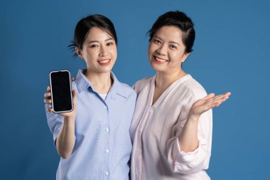 Mavi arka planda poz veren Asyalı bir anne ve çocuğun resmi