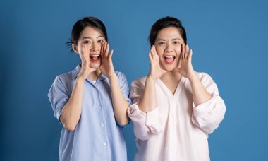 Mavi arka planda poz veren Asyalı bir anne ve çocuğun resmi