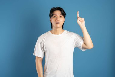 Portrait of asian man posing on blue background clipart