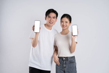 Beyaz arkaplanda poz veren Asyalı çift