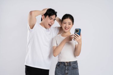 Beyaz arkaplanda poz veren Asyalı çift