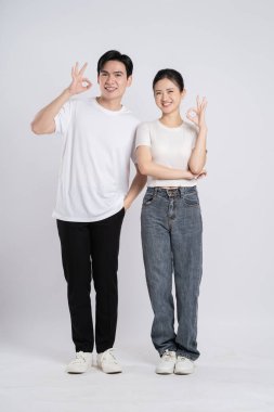 Beyaz arkaplanda poz veren Asyalı çift