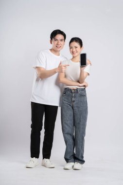 Beyaz arkaplanda poz veren Asyalı çift