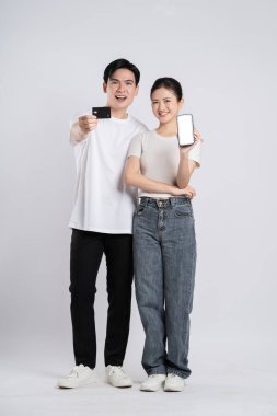 Beyaz arkaplanda poz veren Asyalı çift