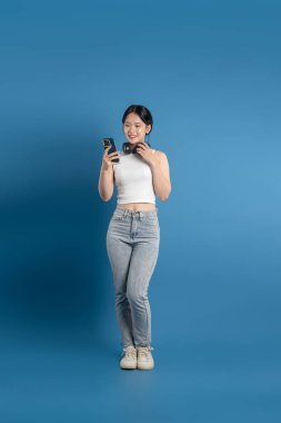 Mavi arka planda poz veren güzel Asyalı kadın portresi