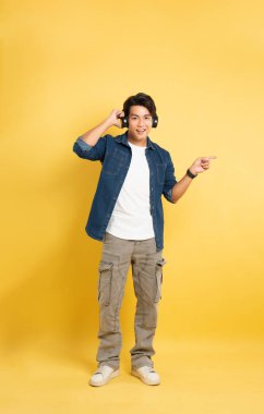 Sarı arka planda poz veren Asyalı adamın portresi