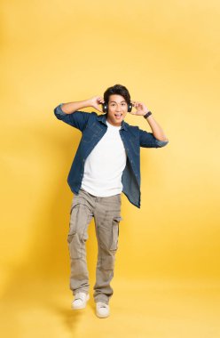 Sarı arka planda poz veren Asyalı adamın portresi