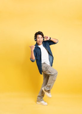 Sarı arka planda poz veren Asyalı adamın portresi