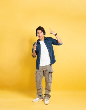 Sarı arka planda poz veren Asyalı adamın portresi