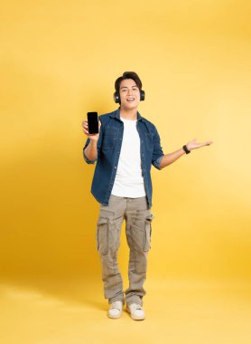 Sarı arka planda poz veren Asyalı adamın portresi