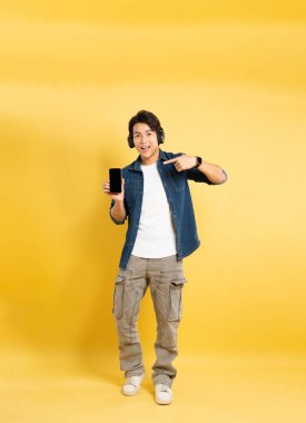 Sarı arka planda poz veren Asyalı adamın portresi