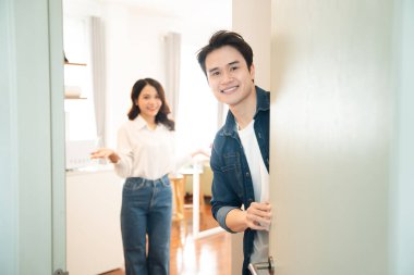 Asyalı bir çift, aydınlık evlerinde sıcak bir ortam yaratarak dostça karşılama yapıyor.