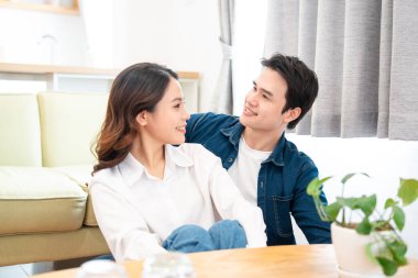 Sevecen bir çift, sıcak ve doğal aydınlatma odalarında dinlenirken aynı sevgi dolu bakışları paylaşır.