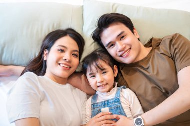 Üç kişilik bir aile arasındaki sevgi ve bağın vurgulandığı neşeli bir an.