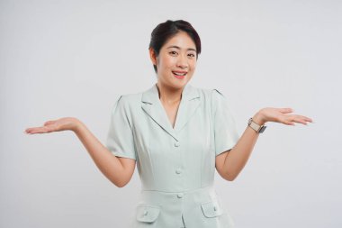 Beyaz bir arka planda izole edilmiş neşeli bir kadın, açık avuçlar ve yumuşak bir gülümsemeyle karşımıza çıkar.