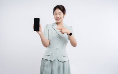 Gülümseyen kadın akıllı telefonu boş ekranla sunuyor. Beyaz arka plana karşı akıllı bir perde takıyor.