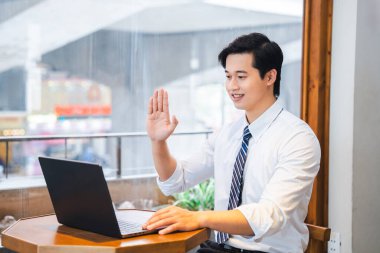 Gömlek ve kravat takan bir adam biriyle görüntülü görüşme yapıyor.