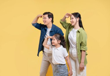 Neşeli bir aile, bir baba ve bir kız da dahil olmak üzere, gündelik giysiler içinde, iyimser bir şekilde ileriye bakıyor.