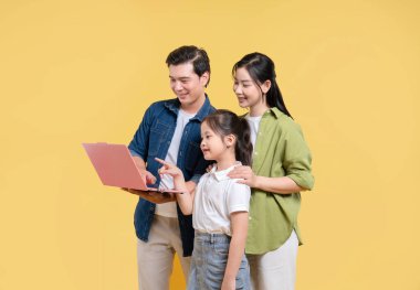 Üç kişilik gülümseyen bir aile dizüstü bilgisayara bakarken bir arada duruyorlar.