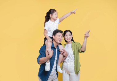 Neşeli bir aile, babasının omuzlarına binen küçük bir kız da dahil olmak üzere geleceğe bakıyor.