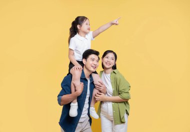 Bir anne ve kız, heyecan ve heyecanla sarı bir zemine karşı birlikte poz verir.