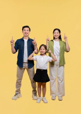 Üç gülücüklü neşeli bir aile. Parlak, güneşli, sarı bir arka plana karşı birlikte hareket ediyorlar.