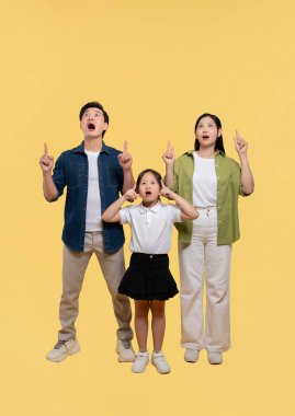 Aile sarı bir zemine karşı duruyor. Meraklı ve şaşırmış bir ifade var.