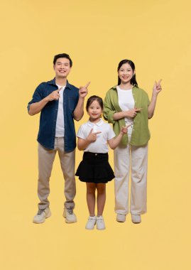 Üç kişilik bir aile ve yan tarafı gösteren genç bir kız. Hepsi parlak sarı bir arka plana gülümsüyor.