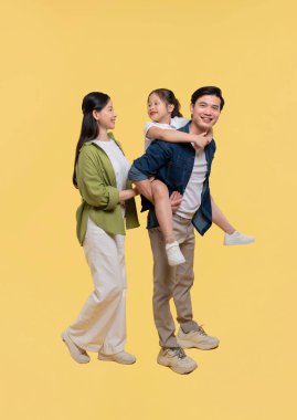 Anne ve babadan oluşan mutlu bir aile sarı arka planda birlikte bir gün geçiriyorlar.