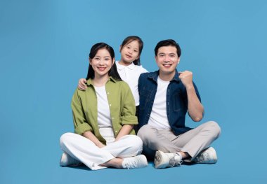 Neşeli aile mavi zeminde poz verir anne ve baba ve kız neşe ve mutluluk saçar