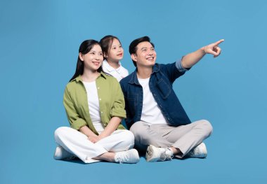 Parlak mavi bir zemin üzerinde mutlu bir aile üç gülüyor ve umutlu ve heyecanlı görünüyor.