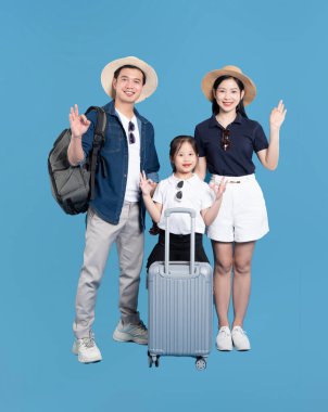 Üç kişilik bir aile, bavullarıyla birlikte aynı aksesuar ve kıyafetlerle tatile çıkmaya hazırlar.