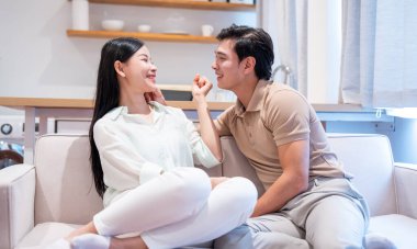 Bir çift, kapalı bir koltukta oturur ve keyifli bir anı paylaşır.