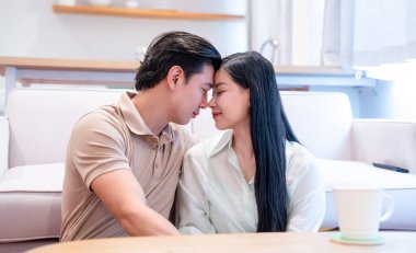 Genç bir çift kapalı alanlarda yan yana eğilir. Yakın bir ilişki ve aşk anında alınlarına dokunur.