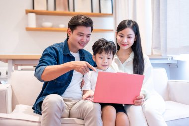 Aileler çocuklarına bilgisayar öğretmek için kanepede sevgi dolu bir ortam yaratarak kaliteli zaman geçirirler.