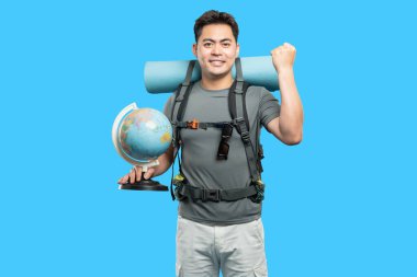 Sırt çantası ve küre ile gülümseyen bir gezgin keşfetmeye hazır parlak mavi bir zemin karşısında.