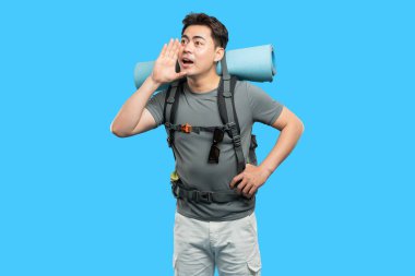 Sırt çantalı gezgin, ağzına yapışan mavi arka plan eliyle sesleniyor.