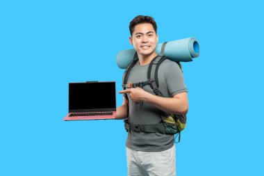 Sırt çantalı gülümseyen bir gezgin modern göçebe yaşam tarzına karşı dizüstü bilgisayar sunar.