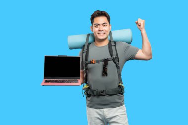 Gülümseyen adam sırt çantası ve dizüstü bilgisayarı mavi Macera ve teknoloji. Seyahat ekipmanları heyecan ve başarı gösteriyor.